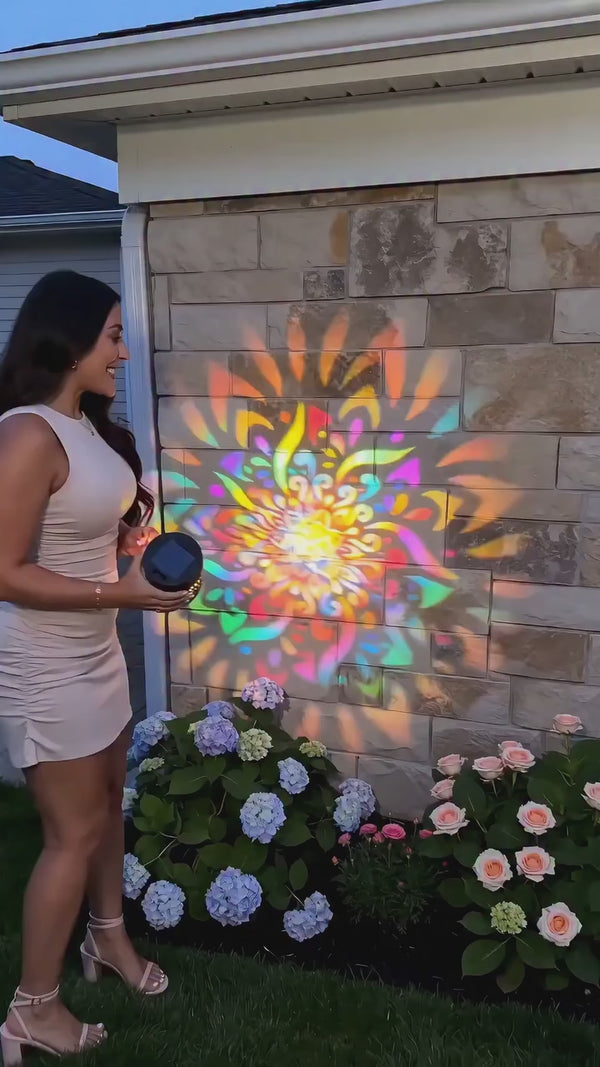Demonstration frame showing colorful mandala light projected on an exterior stone wall